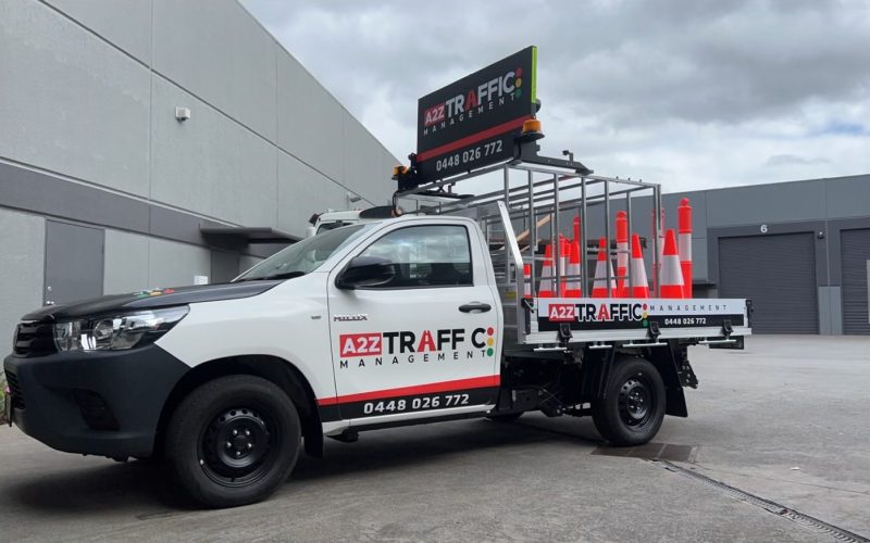 A2Z Traffic Management vehicle equipped with safety cones and electronic signage, parked at a Melbourne industrial site, highlighting professional traffic control and road safety services in Victoria.