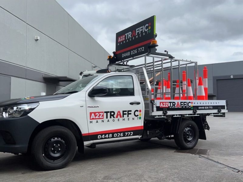 A2Z Traffic Management vehicle equipped with safety cones and electronic signage, parked at a Melbourne industrial site, highlighting professional traffic control and road safety services in Victoria.